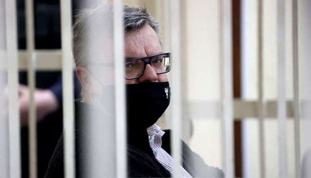 Opposition politician and banker Viktor Babaryko, charged with corruption and money laundering, is seen from inside a defendants' cage during the opening day of his trial in Minsk on February 17. BELTA/AFP