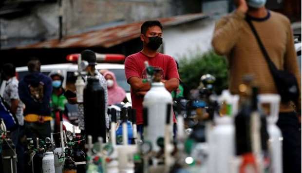 A man wearing a protective mask queues to refill oxygen tanks as Indonesia experiences an oxygen supply shortage amid a surge of coronavirus disease cases, at a filling station in Jakarta, Indonesia. Reuters