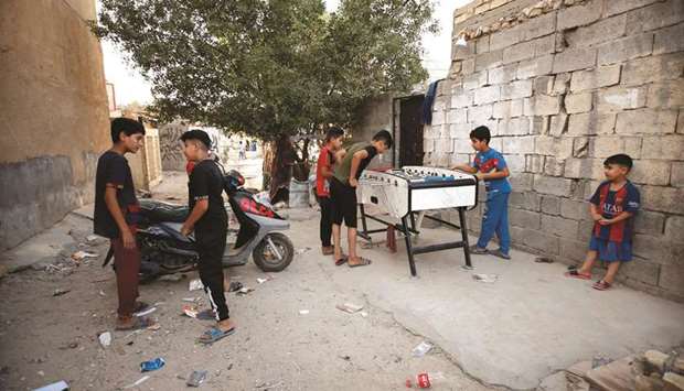 Children play a tabletop football in the street during a power cut in Baghdad. (Reuters)