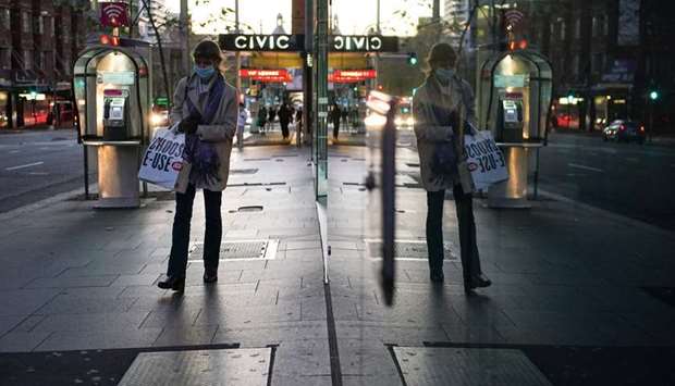 A woman wearing a protective face mask walks through the city centre during a lockdown to curb the spread of a coronavirus disease (Covid-19) outbreak in Sydney, Australia