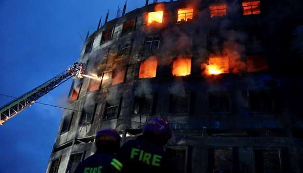 Firefighters work at the scene of a fire that broke out at a factory named Hashem Foods Ltd. in Rupganj of Narayanganj district, on the outskirts of Dhaka, Bangladesh