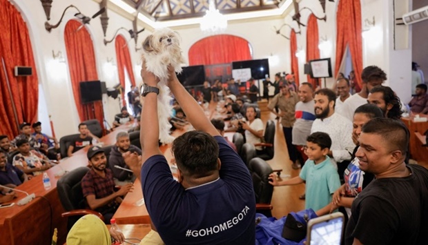 A demonstrator shows a dog as the new ,Wildlife Minister, at the President Gotabaya Rajapaksa's cabinet meeting room, at the President's house, on the following day after demonstrators entered the building, after President Gotabaya Rajapaksa fled, amid the country's economic crisis, in Colombo, Sri Lanka. REUTERS/Dinuka Liyanawatte