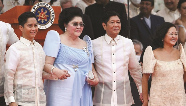 BACK IN BUSINESS: Former first lady Imelda Marcos (second left) holding hands with her grandson, Congressman Sandro Marcos (first left); and son, the new Philippine President Ferdinand Marcos Jr. (second right), who, is holding hands with new first lady Louise Araneta-Marcos (right) after he took his oath of office during the inauguration ceremony at the National Museum in Manila yesterday. (AFP)