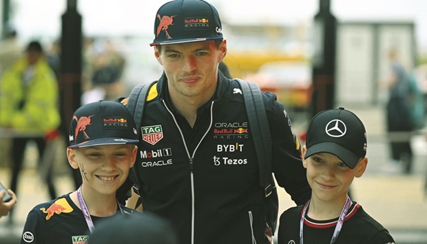 Red Bull Racingu2019s Dutch driver Max Verstappen poses for a photograph with young fans in the paddock ahead of the British Grand Prix in Silverstone, central England, yesterday. (AFP)