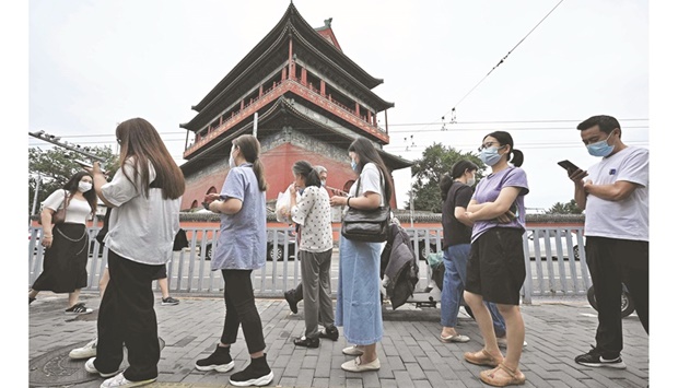 People wait in a queue to be tested for the Covid-19 coronavirus at a swab collection site in Beijing, yesterday.