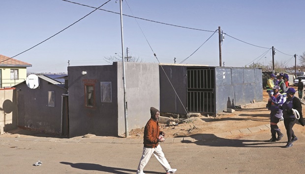 A man walks past the scene where 15 people were killed in a hail of at least 137 bullets by unknown gunmen inside a tavern, in Nomzamo informal settlement, in Soweto, yesterday.