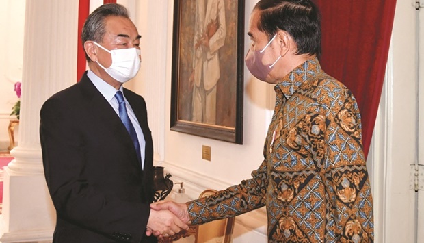 Indonesiau2019s President Joko Widodo shakes hands with Chinese Foreign Minister Wang Yi during a meeting at the Presidential Palace in Jakarta, yesterday.