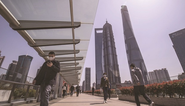 Pedestrians walk through the Lujiazui Financial District in Shanghai. China will unveil a bumper set of economic indicators this week that will likely set the pace for monetary and fiscal stimulus for the rest of the year as Beijing chases down its ambitious growth target.