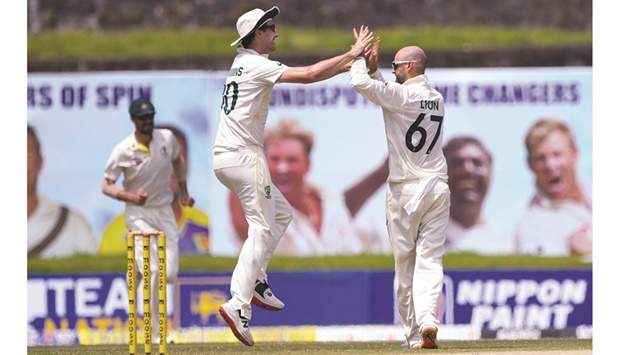 Australiau2019s Nathan Lyon (right) celebrates with Pat Cummins after the dismissal of Sri Lankau2019s Kusal Mendis (not pictured) during the third day of first Test at the Galle International Cricket Stadium in Galle yesterday. (AFP)