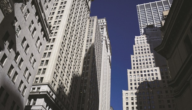 Buildings stand on Wall Street near the New York Stock Exchange. Banks sitting on about $80bn in leveraged buyout financing are pushing to get the debt off their books before market conditions deteriorate.