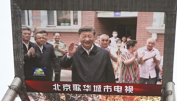 A giant screen shows news footage of Chinese President Xi  Jinping visiting Xinjiang Uyghur Autonomous Region, at a  shopping centre, in Beijing, yesterday.