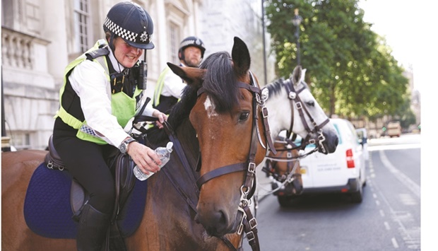A police officer offers water to his mount at Londonu2019s Whitehall.