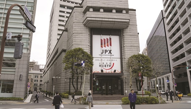 Pedestrians walk by the Tokyo Stock Exchange. The Nikkei 225 closed up 0.7% to 26,961.68 points yesterday.