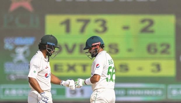 Pakistanu2019s Babar Azam (right) and Abdullah Shafique gesture during the fourth day of first Test against Sri Lanka at the Galle  International Cricket Stadium in Galle yesterday. (AFP)