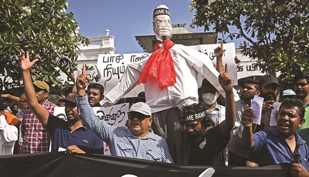 Demonstrators take part in a procession carrying an effigy of interim Sri Lanka President Ranil Wickremesinghe during a protest in front of the Fort railway station in Colombo, yesterday.
