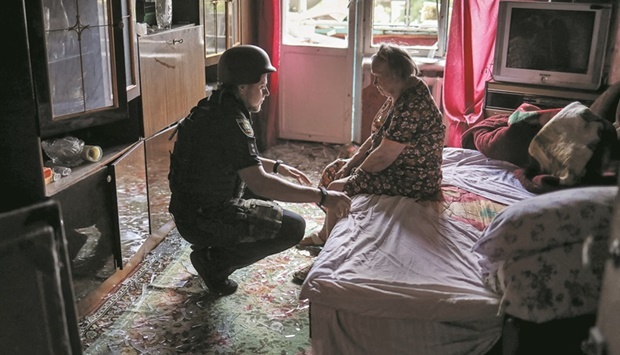 A police officer helps an elderly woman leave her flat in a residential building damaged by a Russian military strike in Kramatorsk, in Donetsk region, Ukraine, yesterday. (Reuters)