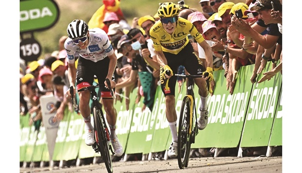 UAE Team Emirates teamu2019s Slovenian rider Tadej Pogacar (left), wearing the best young rideru2019s white jersey, cycles to the finish line alongside Jumbo-Visma teamu2019s Danish rider Jonas Vingegaard u2013 wearing the overall leaderu2019s yellow jersey u2013 to win the 17th stage of the 109th edition of the Tour de France, 129.7km between Saint-Gaudens and Peyragudes, in southwestern France, yesterday. (AFP)