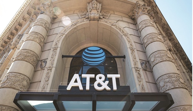 AT&T Inc signage is displayed on a store in San Francisco. AT&T said that more of its customers are starting to put off paying their phone bills, leading the wireless  carrier to cut its forecast for free cash flow this year by $2bn.