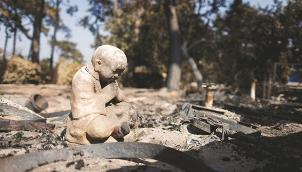 A burned statue is seen at the u2018Les Flots Bleusu2019 camping site, ravaged by a wildfire in La Teste-de-Buch forest near the Dune of Pilat, in the Gironde region of southwestern France.