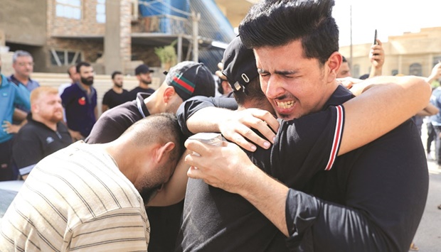 Men react as mourners carry the coffin of a victim, who was killed in an attack on a mountain resort in Iraqu2019s northern province Dohuk, during a funeral in Baghdad, yesterday.