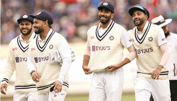 Indiau2019s Jasprit Bumrah (second right and below) and teammates walk off the field during a rain delay on day two of the one-off Test against England at Edgbaston, Birmingham, yesterday. (Reuters)
