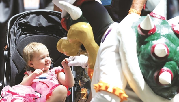A Comic-Con visitor dressed up as Super Mario character Bowser greets a child at the 2022 Comic-Con International: San Diego.