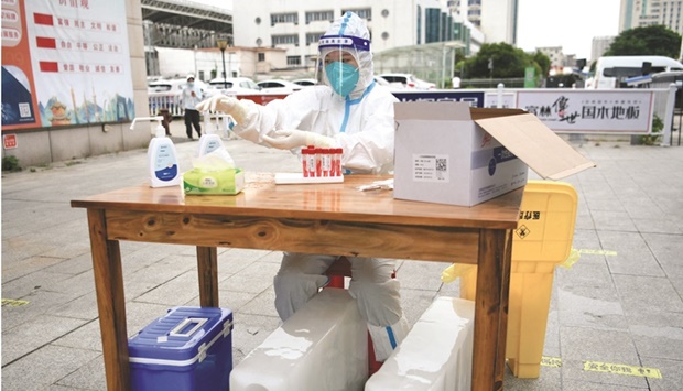 A medical worker sits with ice blocks at a nucleic acid testing site in Nanchang of Jiangxi province in China, during preparations to test residents for the coronavirus disease (Covid-19).