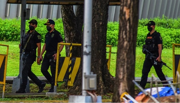 Police officers patrol the scene after three people were killed in a shooting at Ateneo de Manila University in Quezon City, suburban Manila, on July 24, 2022.
