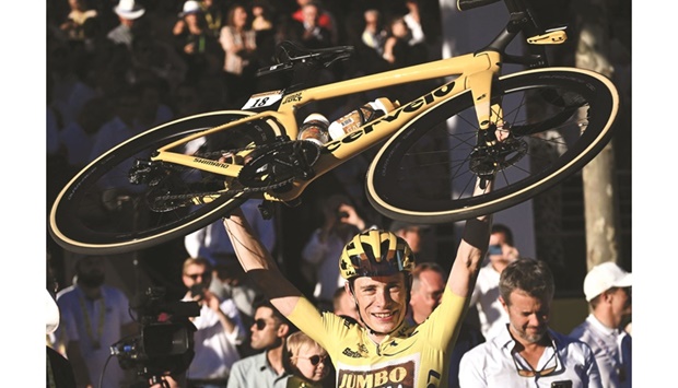 Jumbo-Visma teamu2019s Danish rider Jonas Vingegaard,  wearing the overall leaderu2019s  yellow jersey, raises his bicycle as he celebrates winning the 109th edition of the Tour de France cycling race, after the 21st and final stage, 115.6km between La Defense Arena in Nanterre, outside Paris, and the Champs-Elysees in Paris, France,  yesterday. (AFP)