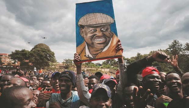 A supporter holds a painted portrait of Azimio La Umoja Coalition presidential candidate Raila Odinga during a campaign rally in Murangu2019a, yesterday, ahead of Kenyau2019s August 2022 general election.