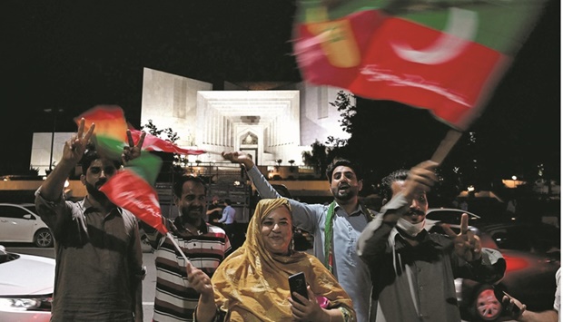 Supporters of former prime minister Imran Khan celebrate in Islamabad yesterday after the Supreme Court declared his candidate the chief minister of Punjab province. (AFP)