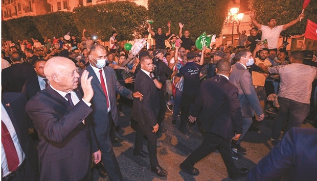 Tunisiau2019s President Kais Saied greets his supporters after a referendum on a new constitution in Tunis.