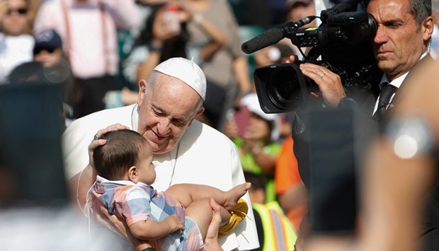 Pope Francis blesses a baby as he arrives to preside a mass at Commonwealth Stadium in Edmonton, Alberta yesterday. (Reuters)