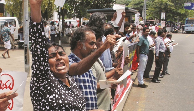 Anti-government demonstrators shout slogans during a protest in front of the Fort Railway Station in Colombo, yesterday.