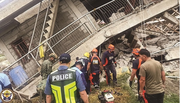 Emergency crew conduct rescue operations outside a building that collapsed during the earthquake, in La Trinidad, Benguet, yesterday.