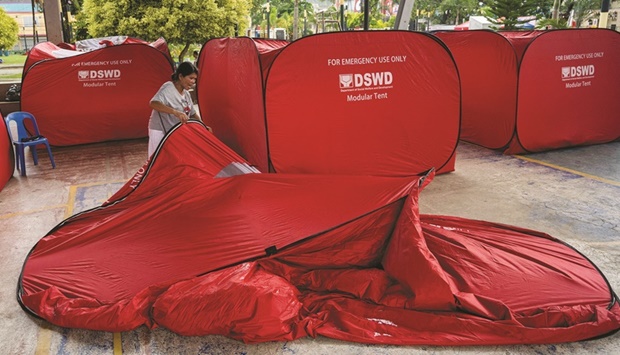 A woman prepares her modular tent in the aftermath of an earthquake in Bangued.