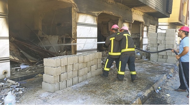 Libyan firefighters extinguish a flame at the House of Representatives in the eastern city of Tobruk yesterday, after angry protesters stormed the building ransacking its offices and torching part of it.