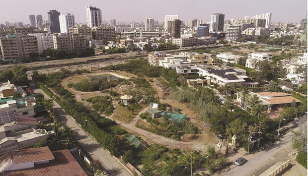 An aerial view shows the urban forest with the business district in the background in Karachi.