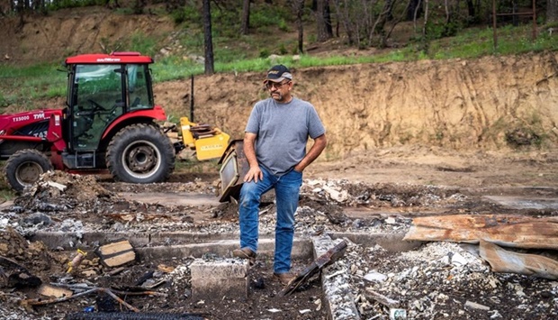 Daniel Encinias stands in the remains of the home he built, which was lost in a wildfire sparked by U.S. Forest Service (USFS) prescribed burns supposed to reduce wildfire risk and which later went out of control, in Tierra Monte, New Mexico, U.S. July 24, 2022.