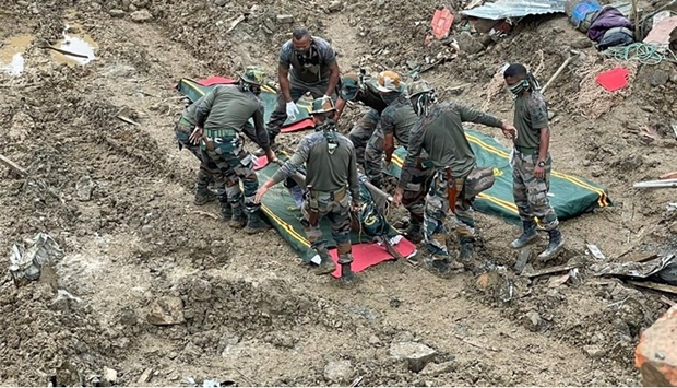In this handout photo released by the Indian Army and taken on July 2, 2022, soldiers carry the body of a victim during rescue efforts after a landslide in Noney district, some 50 Km from Manipur's capital Imphal.