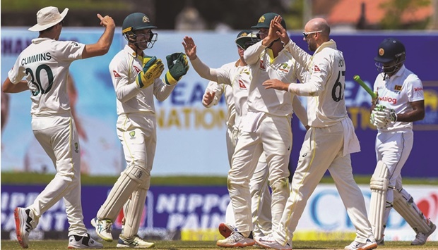 Australiau2019s Nathan Michael Lyon (second right) celebrates with teammates after the dismissal of Sri Lankau2019s captain Dimuth Karunaratne (right) during the third day of play of the first Test at the Galle International Cricket Stadium in Galle on July 1, 2022. (AFP)