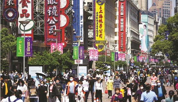 People walk along Nanjing Pedestrian Road, a main shopping area, in Shanghai.