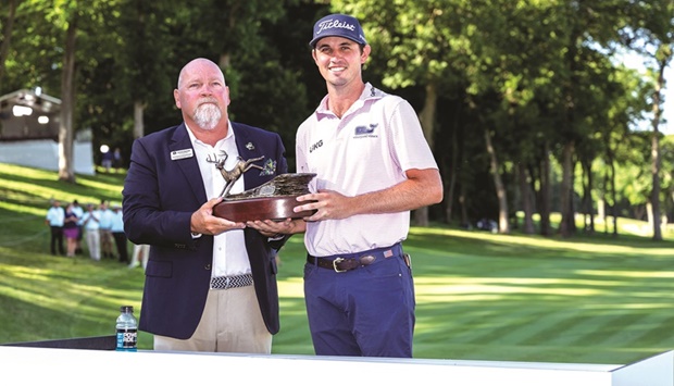 JT Poston is presented his trophy by tournament chair Patrick Eikenberry after winning the John Deere Classic golf tournament in Silvis, Illinois. (USA TODAY Sports)