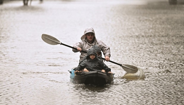 People kayak along a flooded street due to torrential rain in the Windsor suburb of Sydney yesterday.