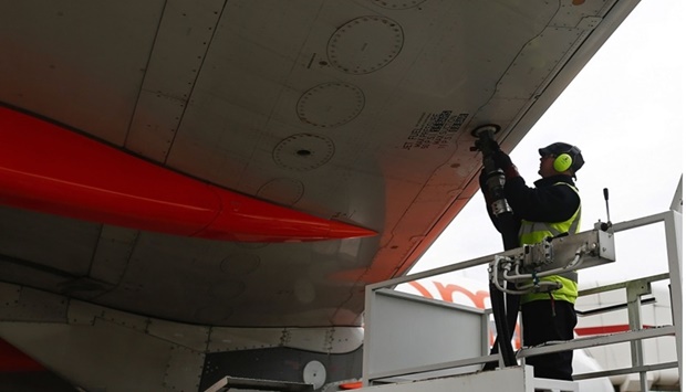 A member of the ground crew connects a fuel hose to the wing of an Airbus aircraft, operated by EasyJet, during the refuelling process between flights at the north terminal of London Gatwick airport in Crawley. The oil price has been sliding on concerns of global economic slowdown hurting energy consumption, but the airline industry has little to cheer given elevated prices for jet fuel.