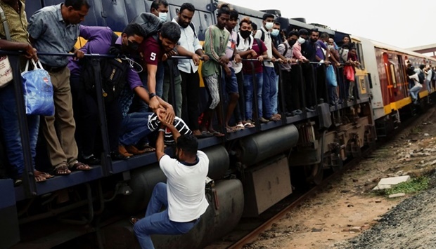 A passenger is helped by others to get to the engine compartment of an overcrowded train as other public transports are being disturbed due to major fuel shortage, amid the country's economic crisis, in Colombo, Sri Lanka. REUTERS
