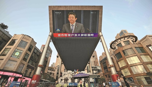    A large video screen in Beijing shows a news broadcast yesterday, featuring an image of Abe.