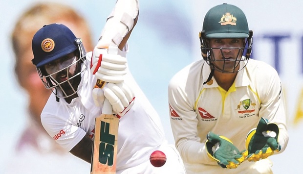 Sri Lankau2019s Kusal Mendis (left) plays shot as Australiau2019s Alex Carey looks on during the second day of the second Test at the Galle International Cricket Stadium in Galle yesterday. (AFP)