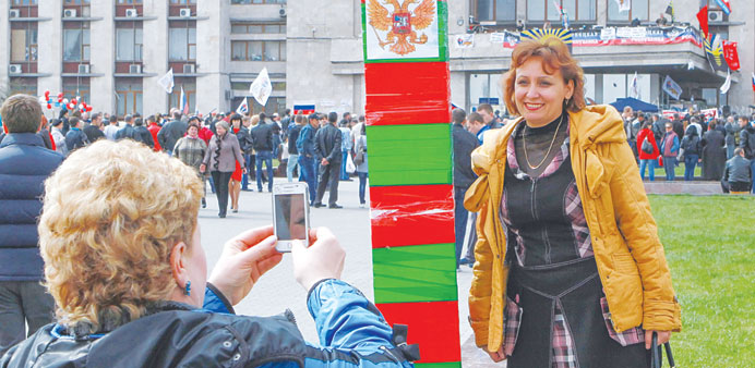    Two women take photos near a symbolic boundary during a pro-Russian rally in front of the occupied regional administration building in Donetsk.