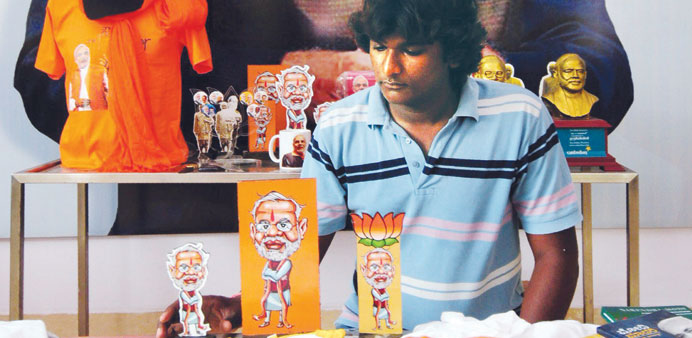 A shopkeeper arranges publicity materials such as stickers, T-shirts, mugs and masks of Narendra Modi at an exclusive showroom in Bangalore yesterday.